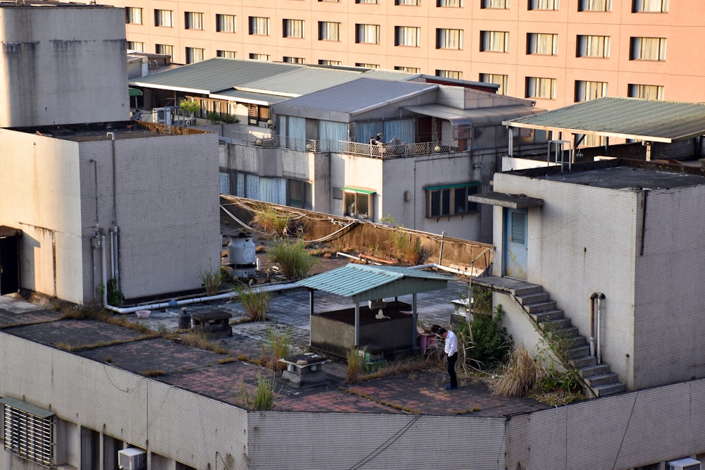 a man standing on top of a roof next to a building