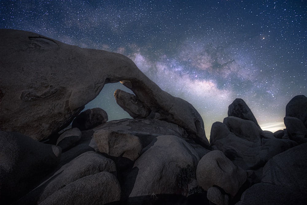 Una formación rocosa con una vista de las estrellas en el cielo