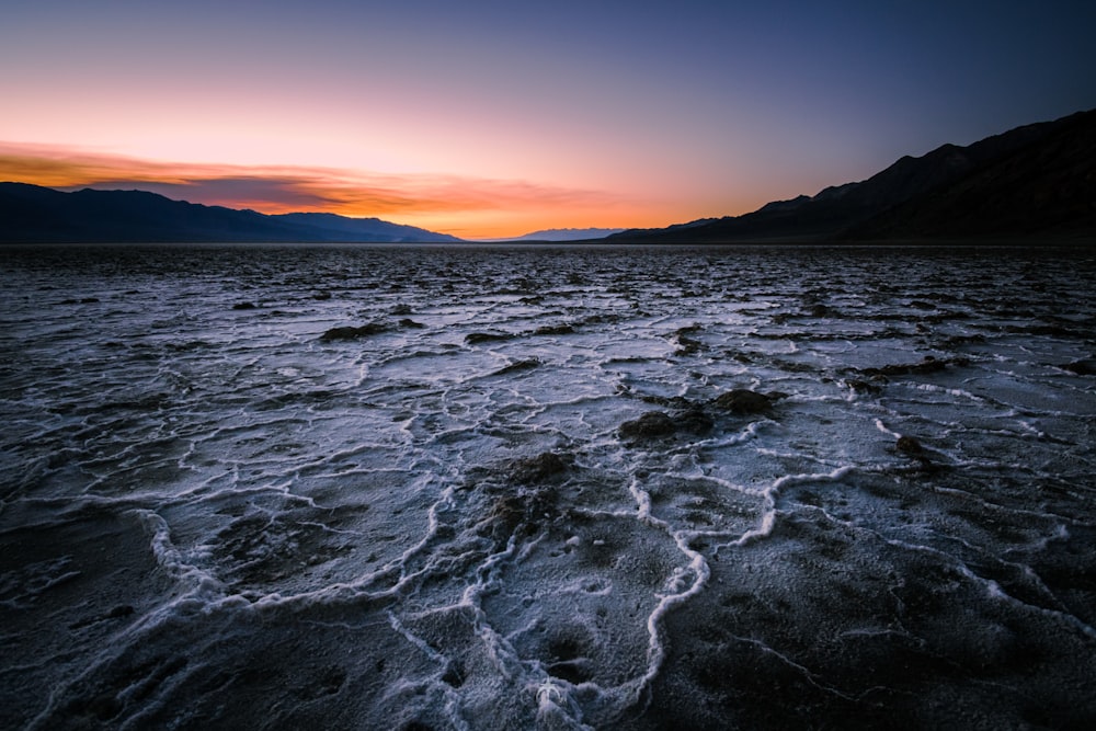 a body of water with a sunset in the background