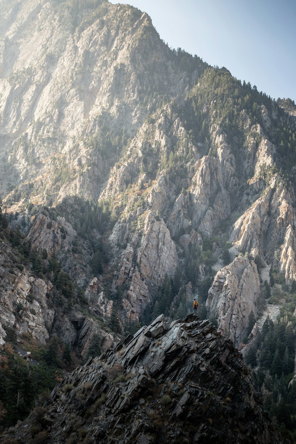 una persona in piedi sulla cima di una montagna rocciosa