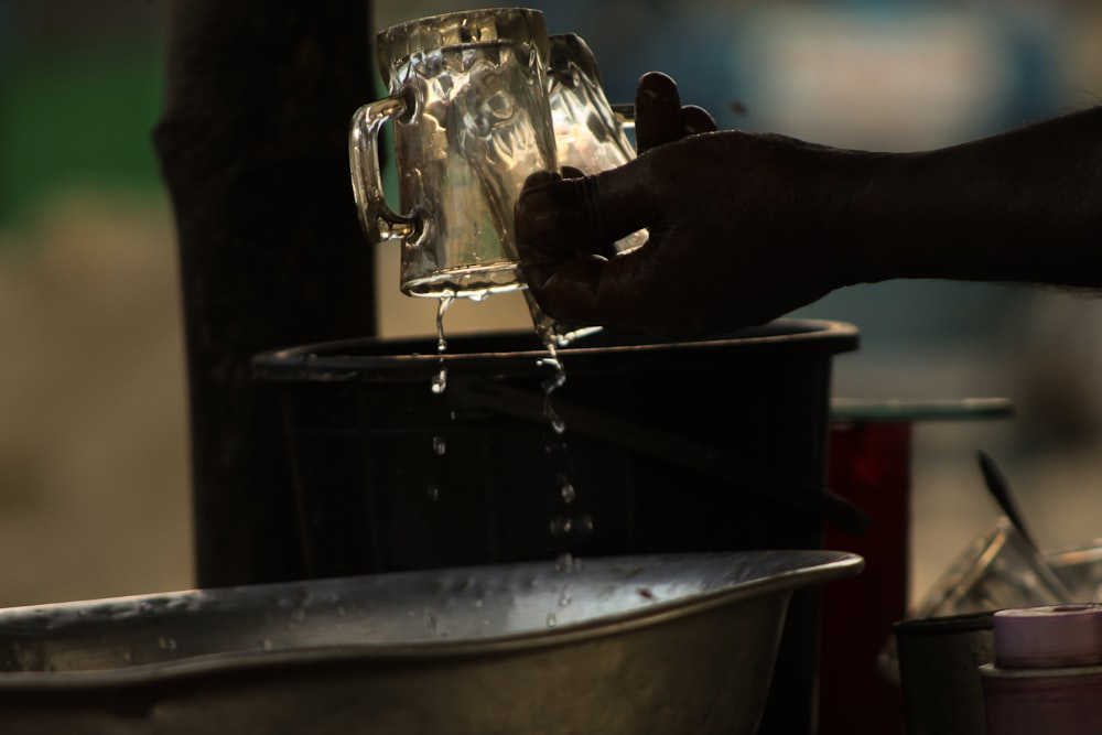 a person is pouring water into a bucket