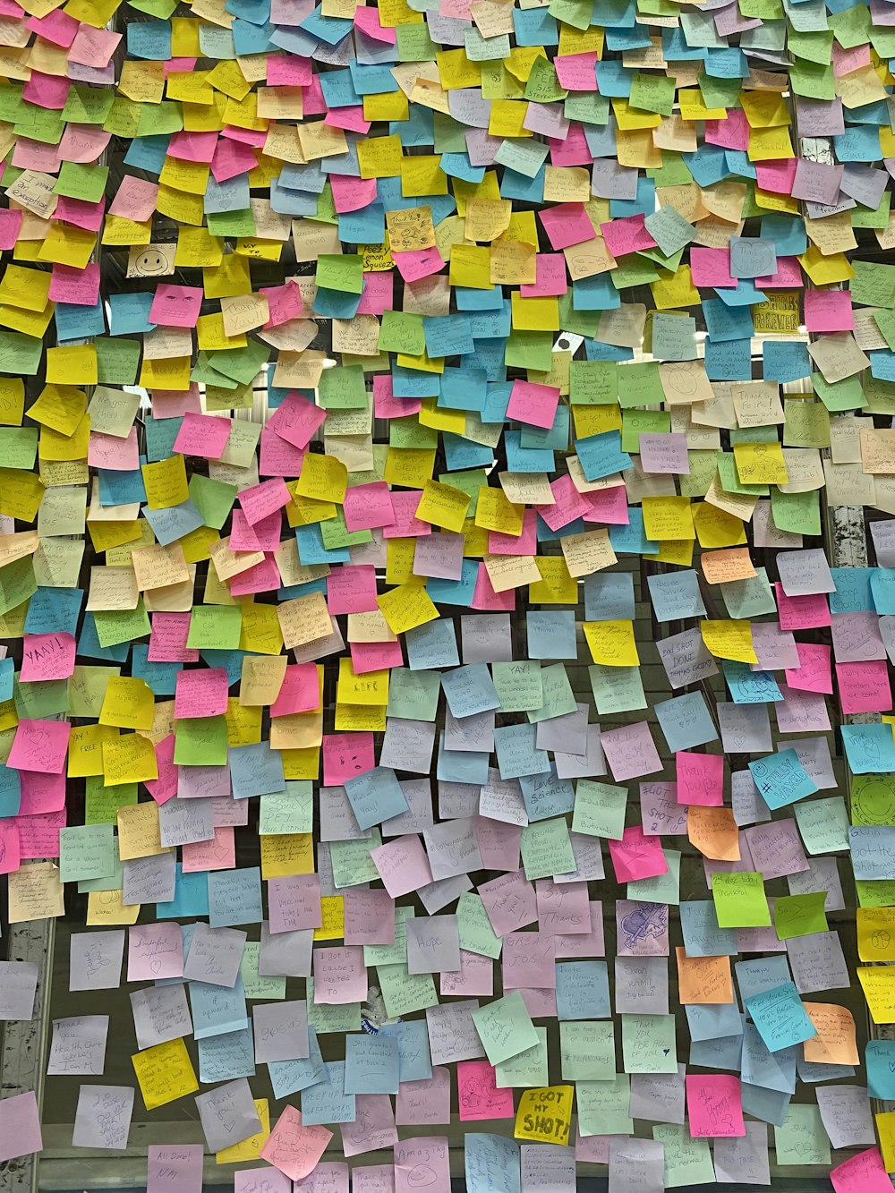 a large amount of post it notes on a wall