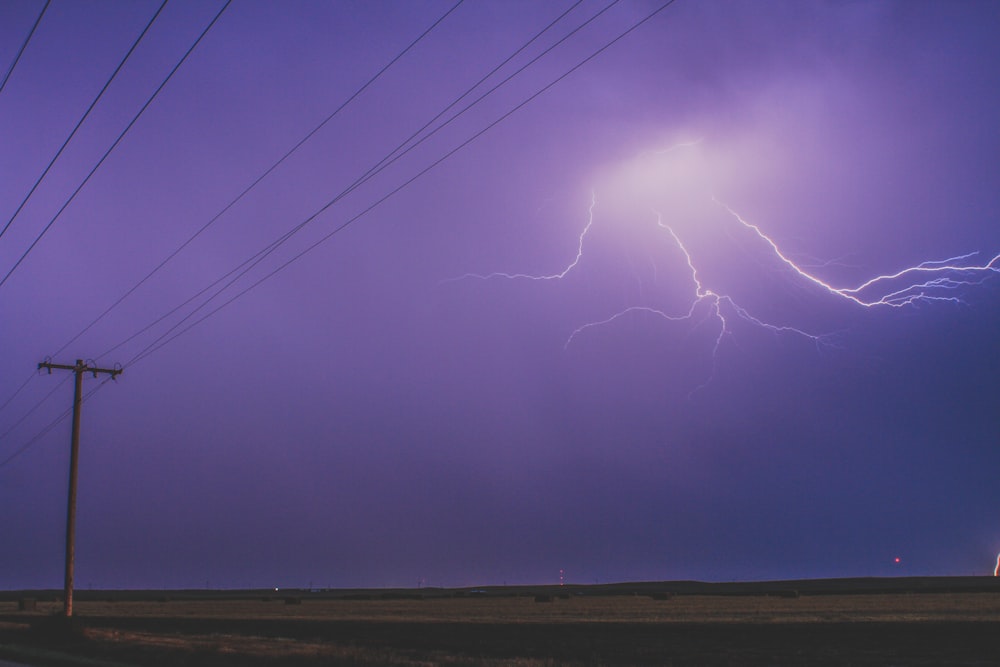 a lightning bolt is seen in the sky above a road