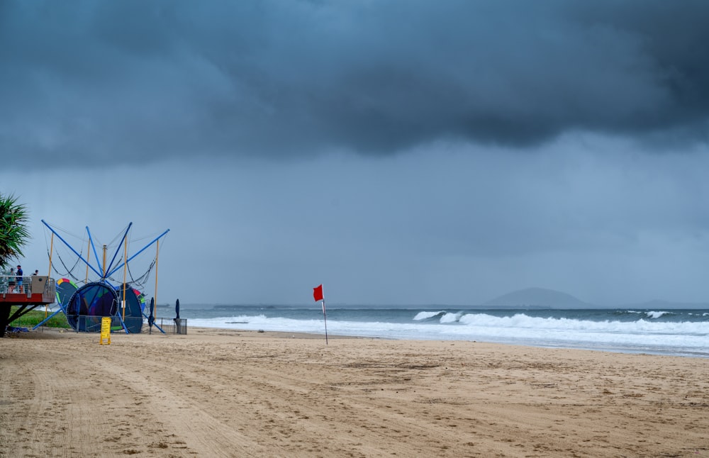a cloudy day at the beach with a lifeguard station