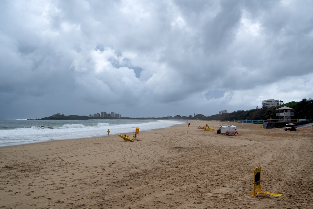 a cloudy day at the beach with people on the sand