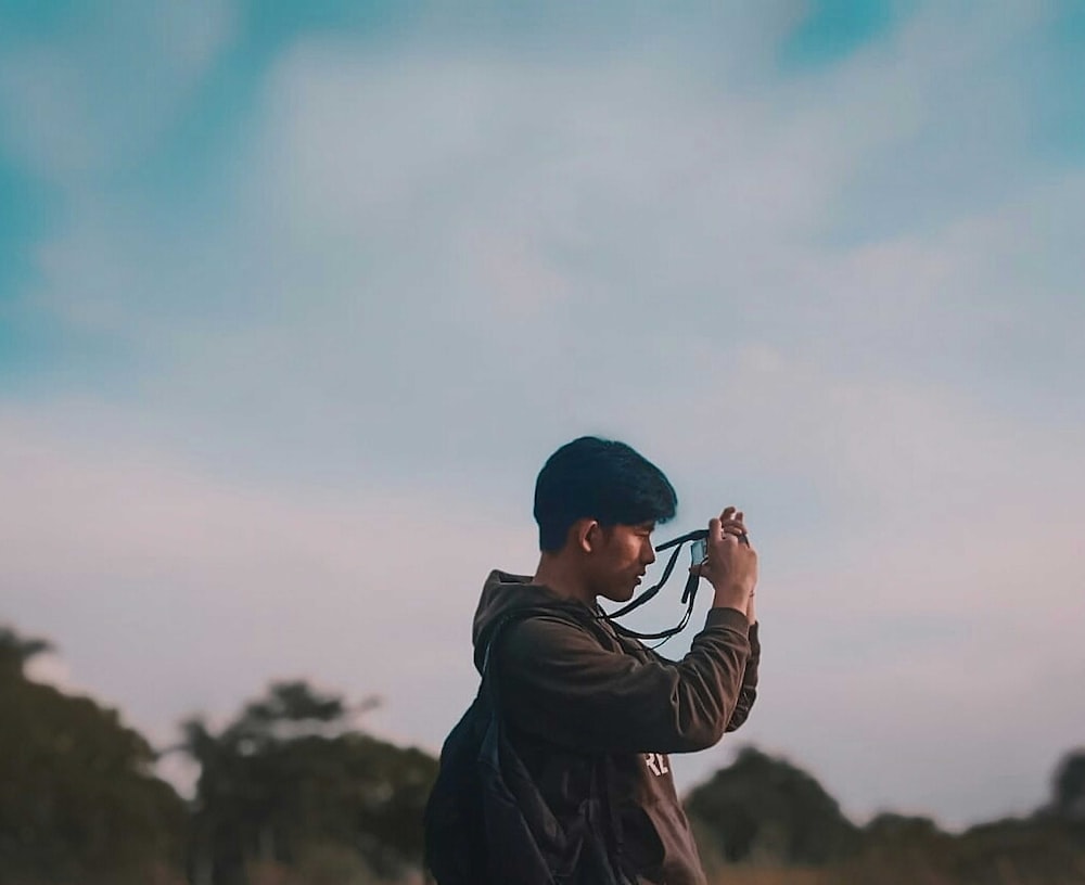 Un hombre sosteniendo una cámara para tomar una foto