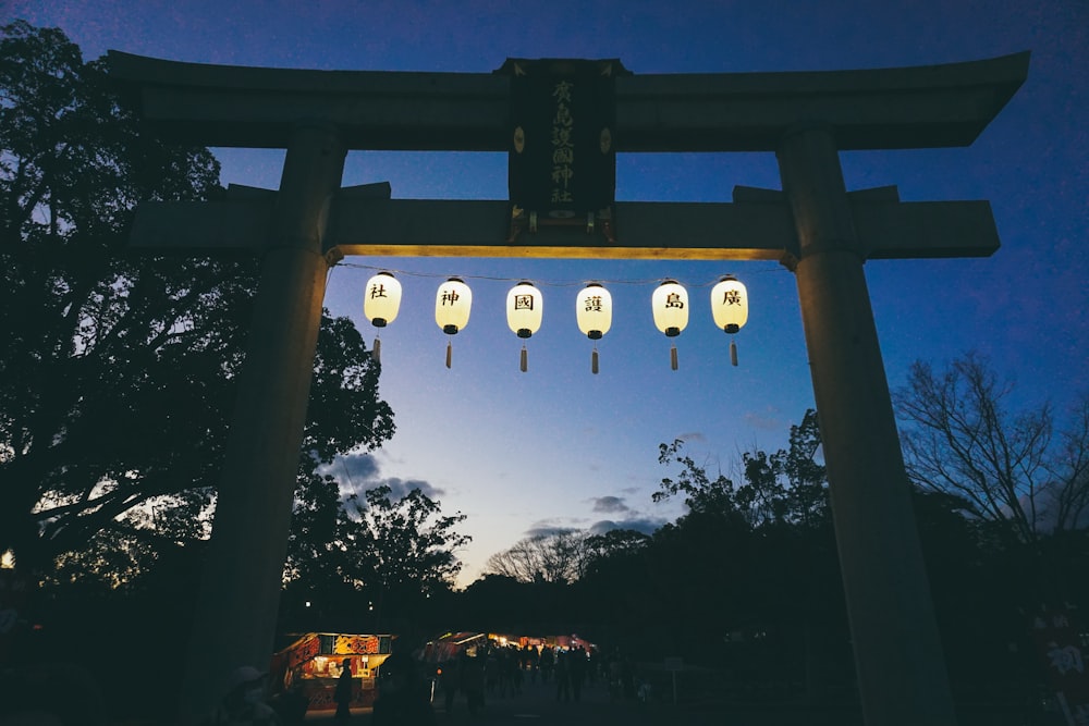 a group of lanterns hanging from the side of a tall structure