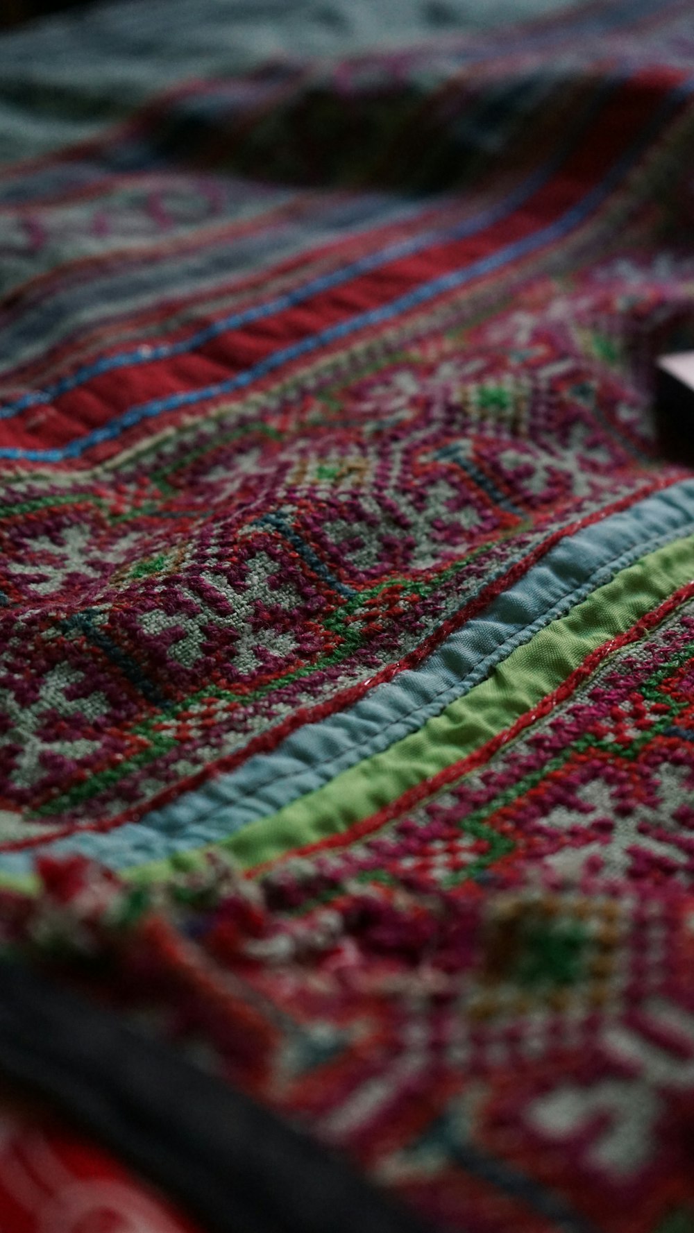 a cell phone laying on top of a colorful blanket