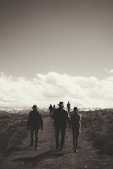 a group of people walking down a dirt road