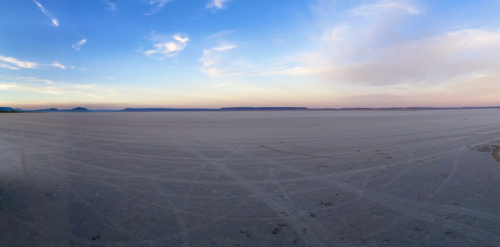 a wide expanse of sand with a blue sky in the background