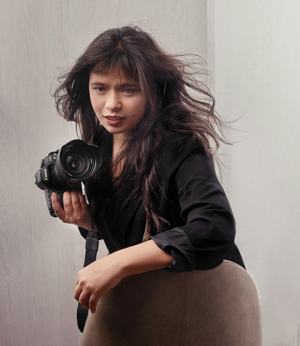 a woman sitting in a chair holding a camera