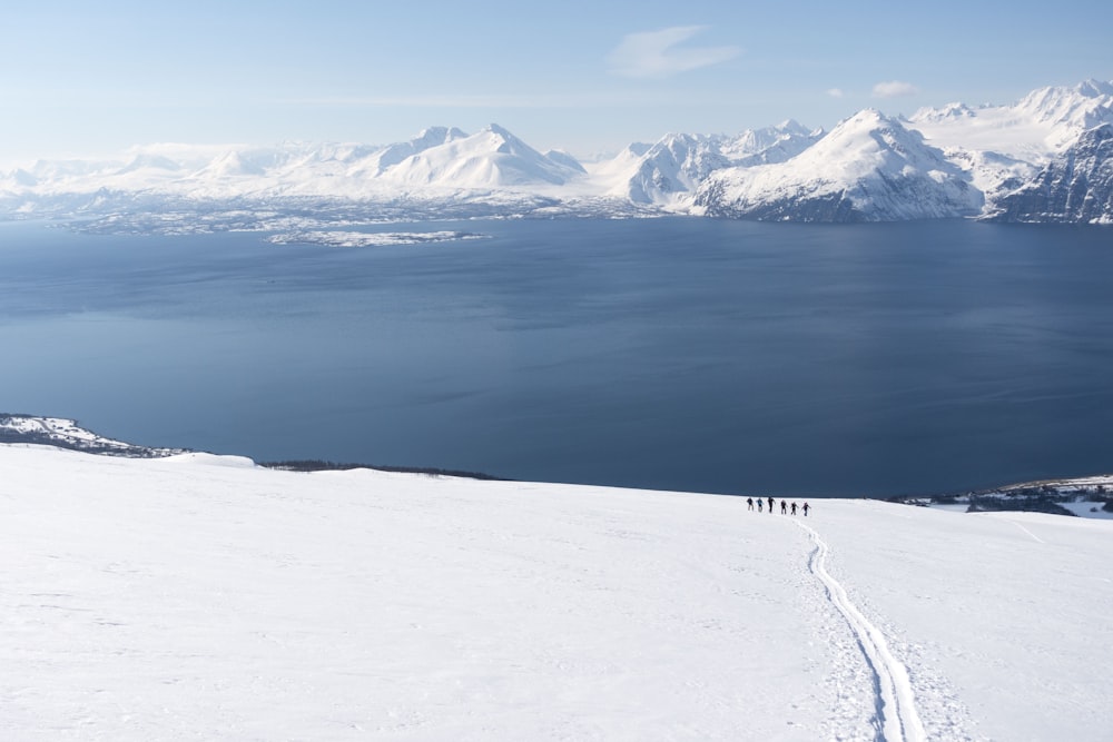 a group of people walking across a snow covered slope