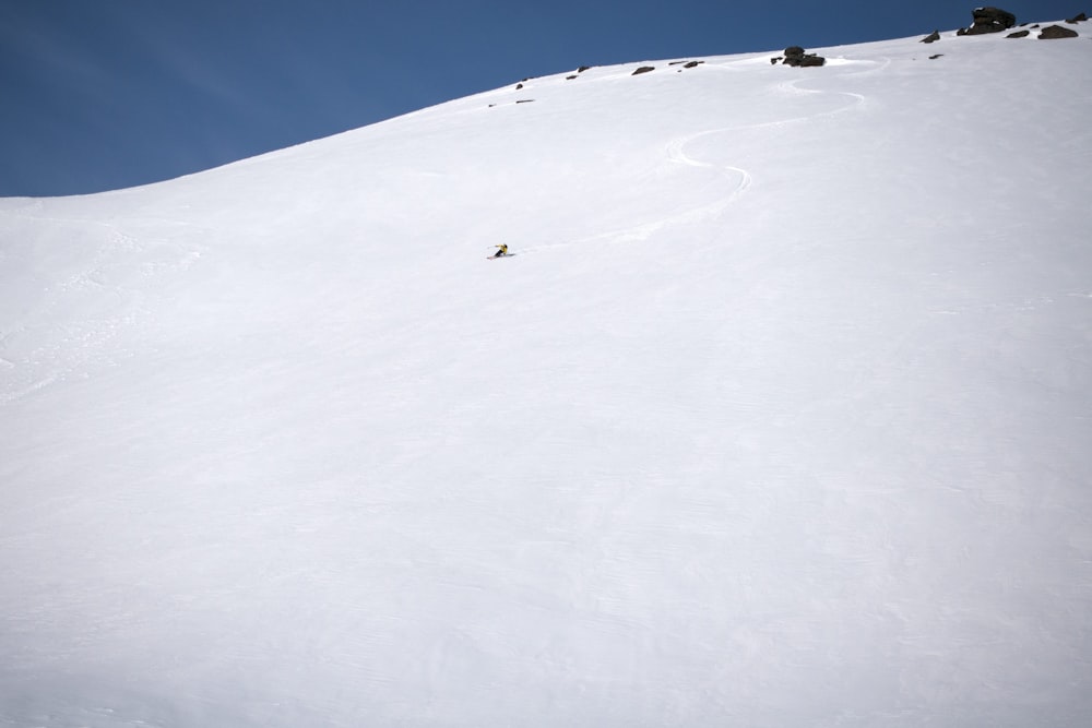 a person riding skis down a snow covered slope