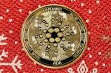 a close up of a gold medallion on a red background