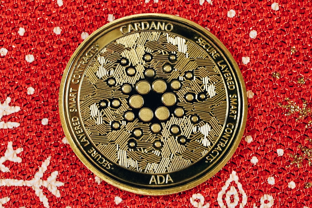 a close up of a gold medallion on a red background