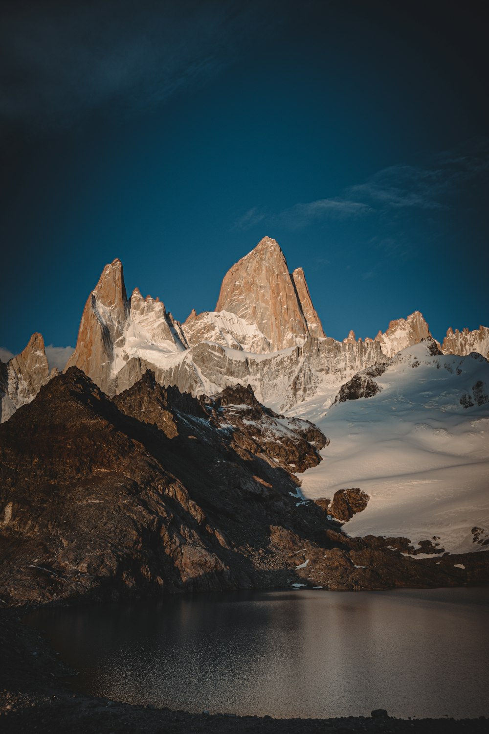 a mountain range with a lake in the foreground