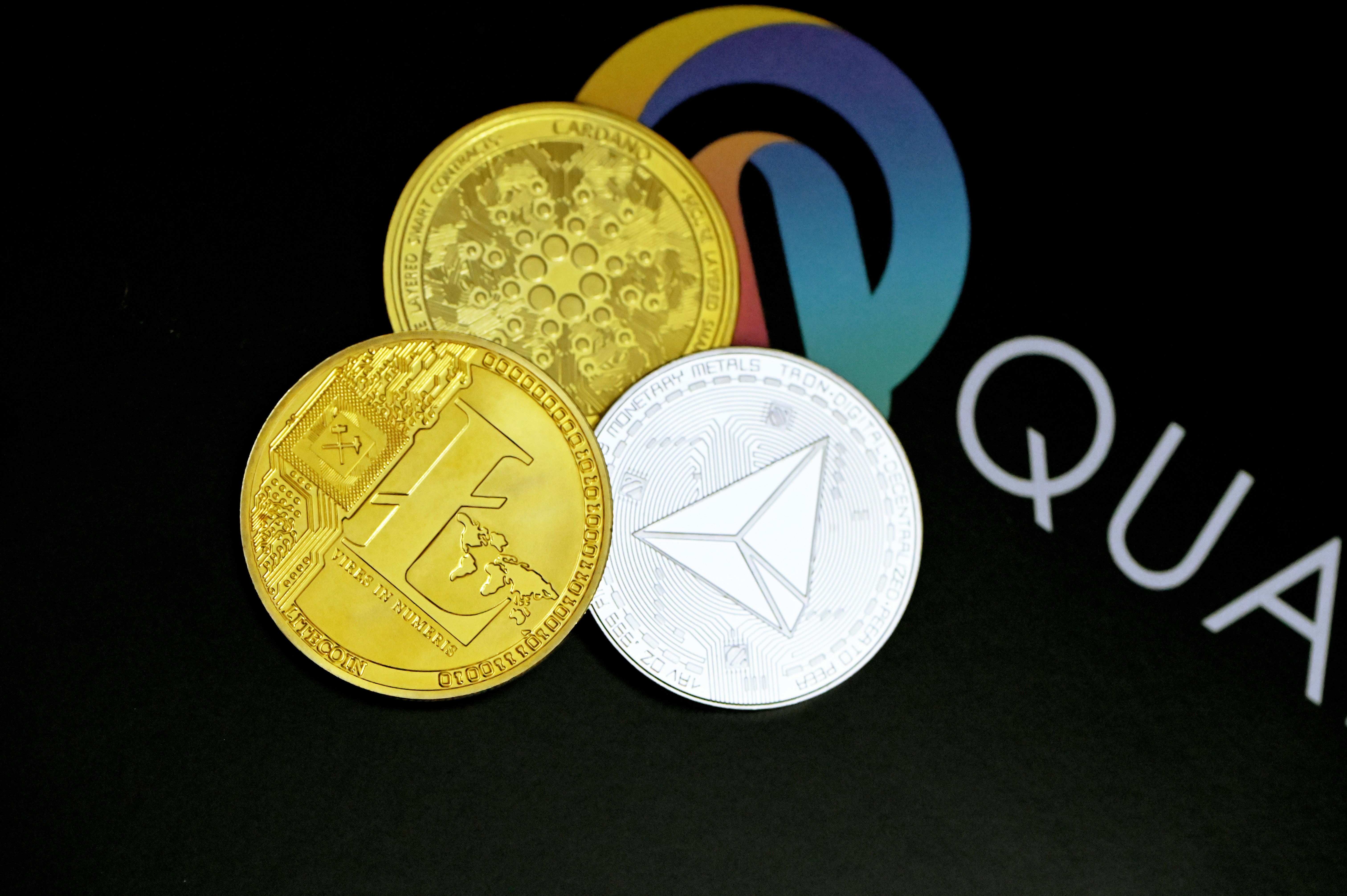 Litecoin, Cardano coin, and Tron coin are together on the Quantitatives logo