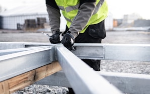 a man in a safety vest is working on a rail