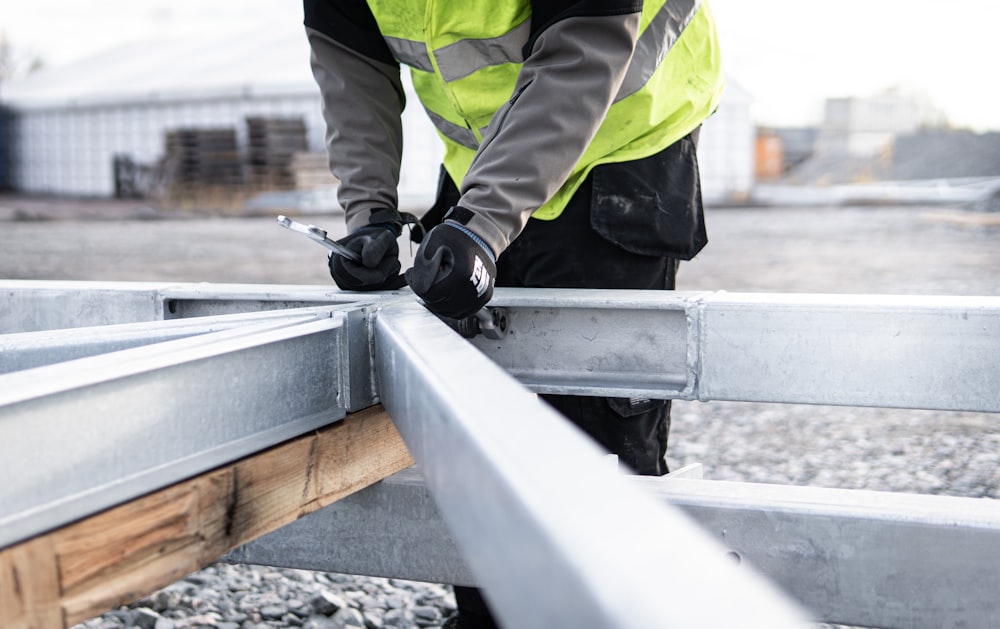 a man in a safety vest is working on a rail