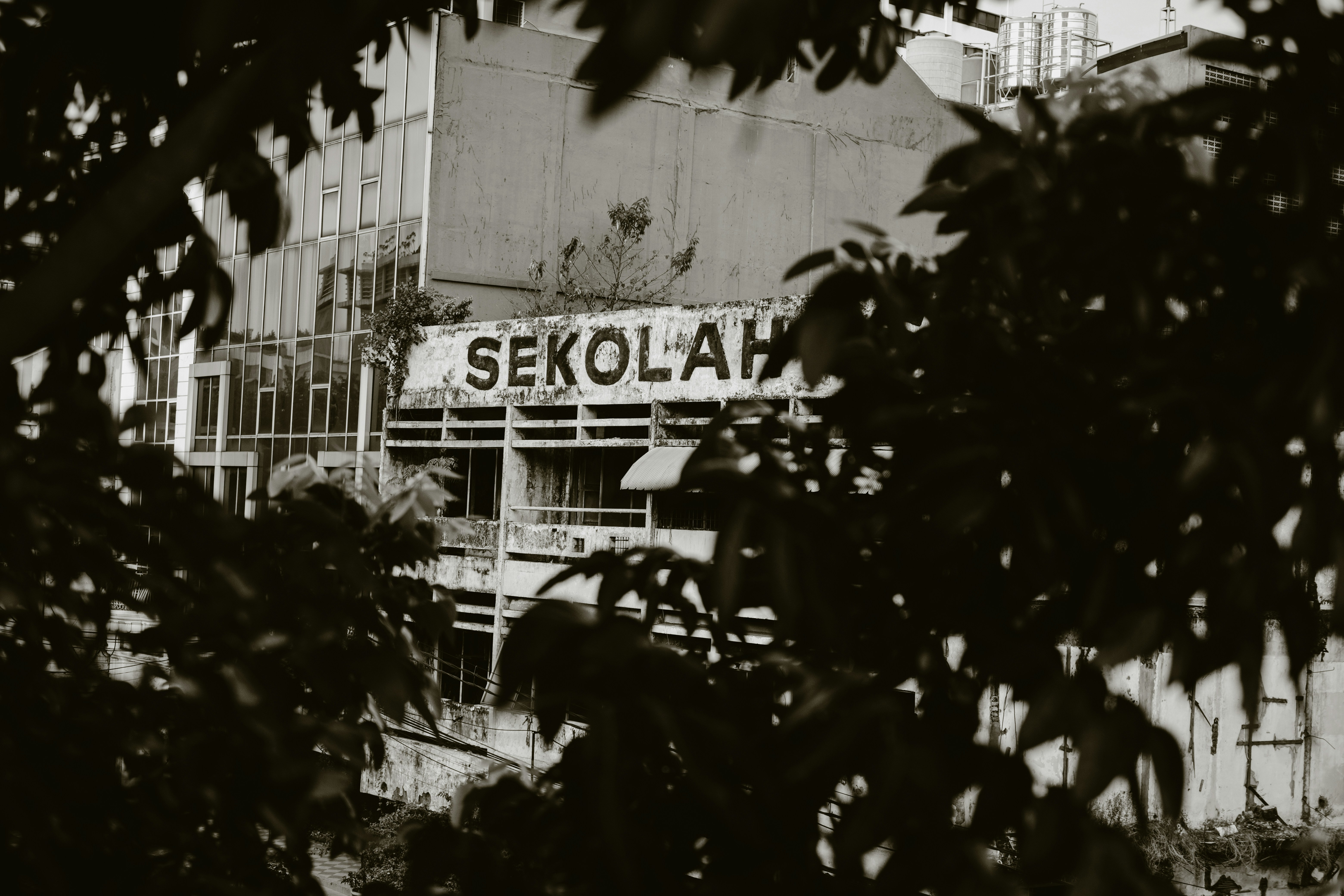 a black and white photo of a building with a sign on it, abandoned school