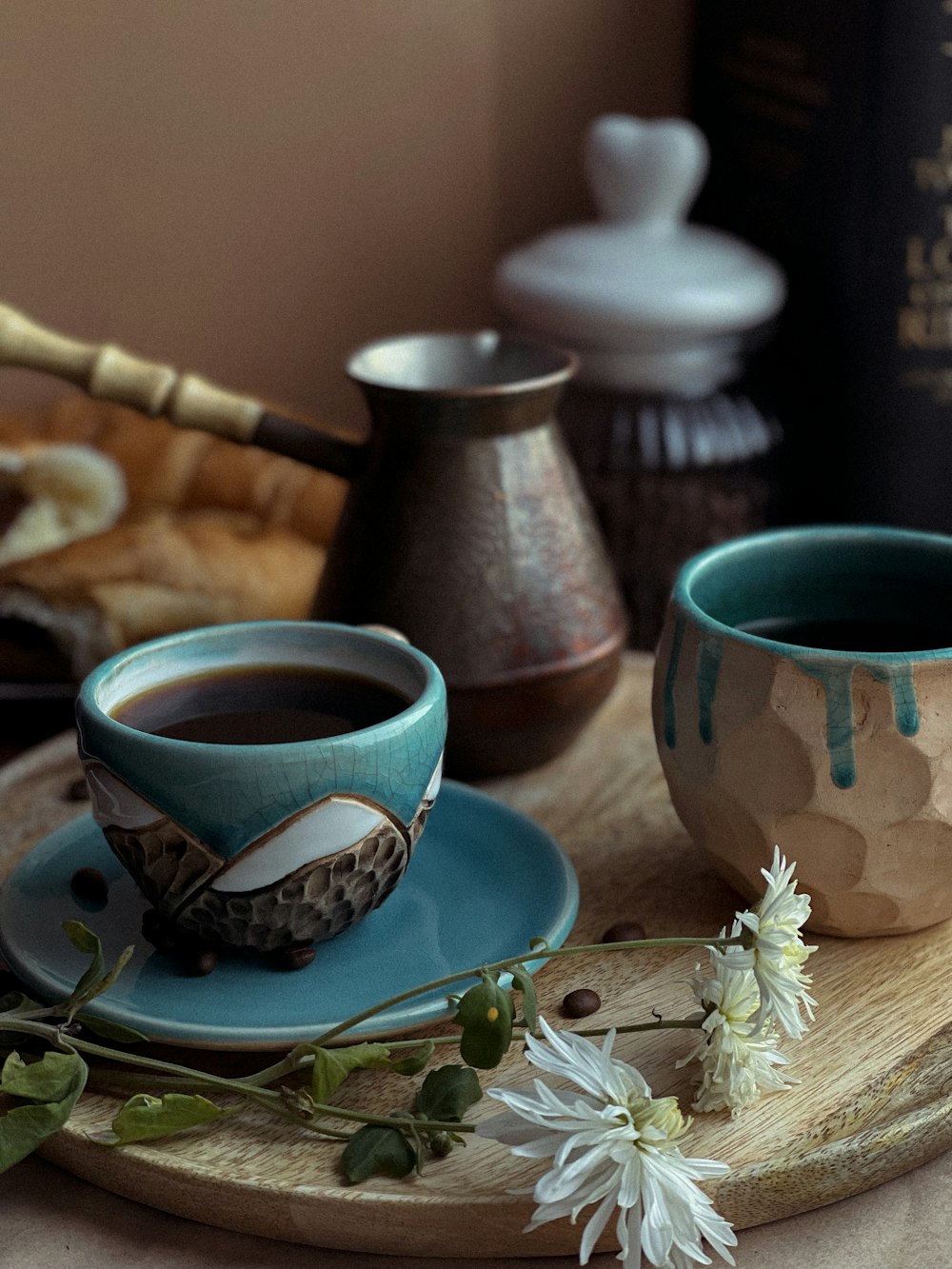 two cups of coffee sit on a tray