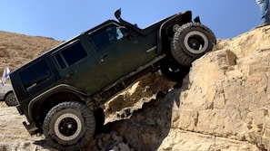 An off-road vehicle climbing a steep rocky hill.