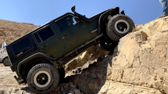An off-road vehicle climbing a steep rocky hill.
