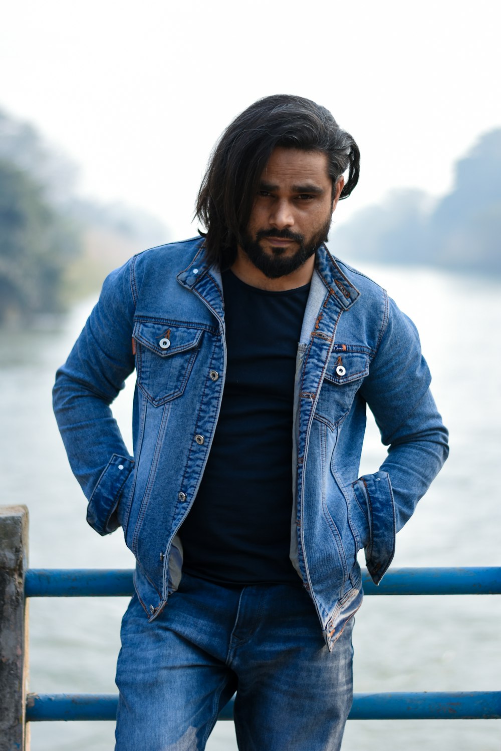 a man with long hair wearing a denim jacket