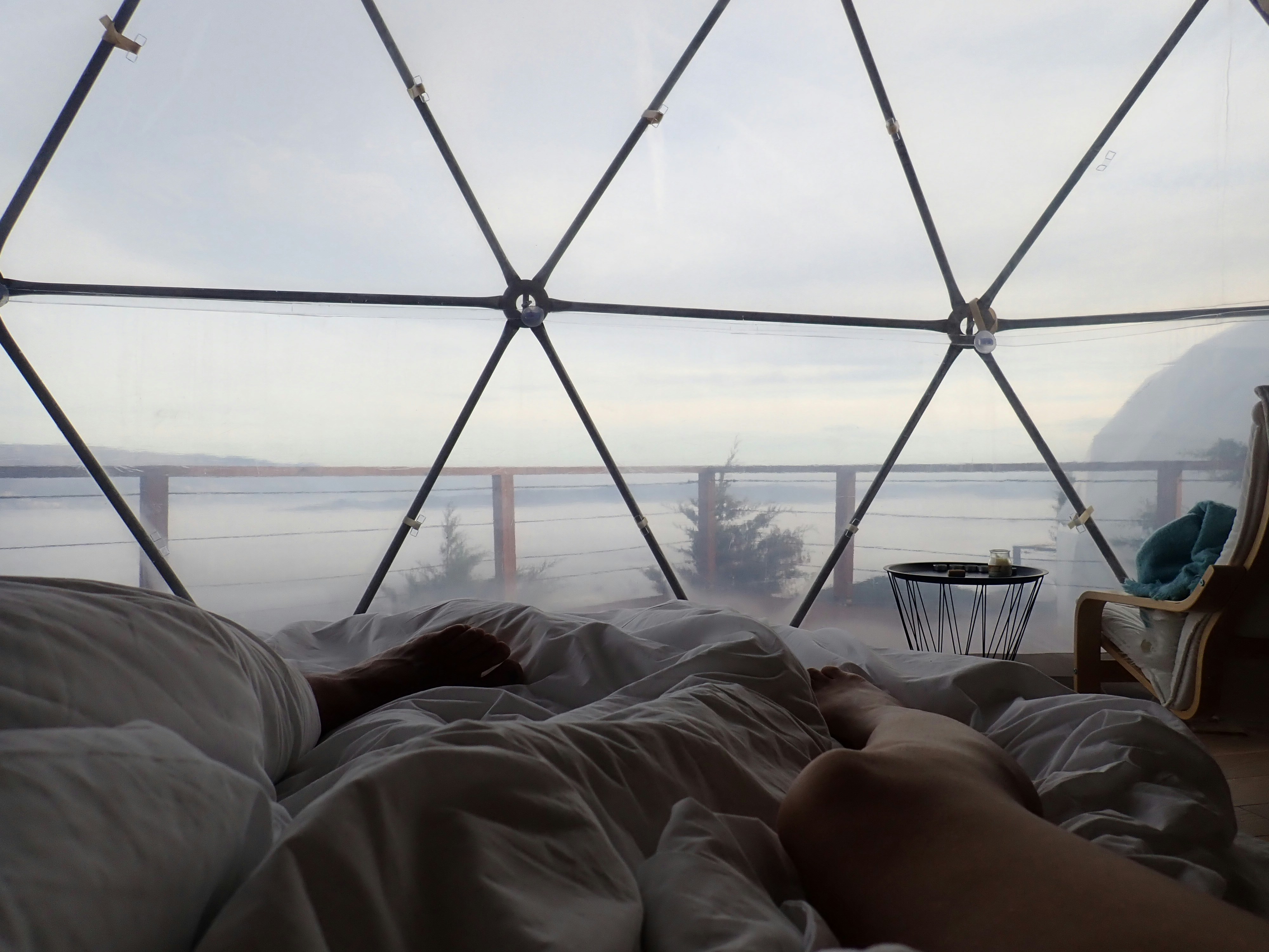 a person laying in a bed in front of a window