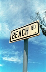 a white and black street sign sitting on top of a metal pole