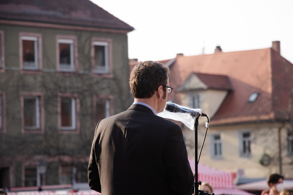 Un uomo in giacca e cravatta che parla in un microfono