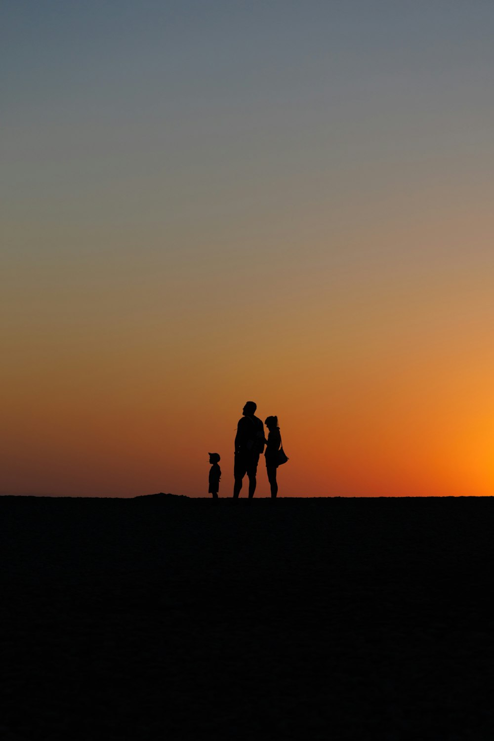 a group of people standing on top of a sandy beach