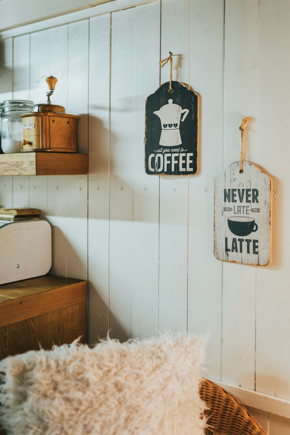 a room with a bed, a table, and two signs on the wall