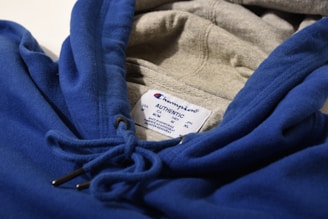 a close up of a blue hoodie with a tag on it