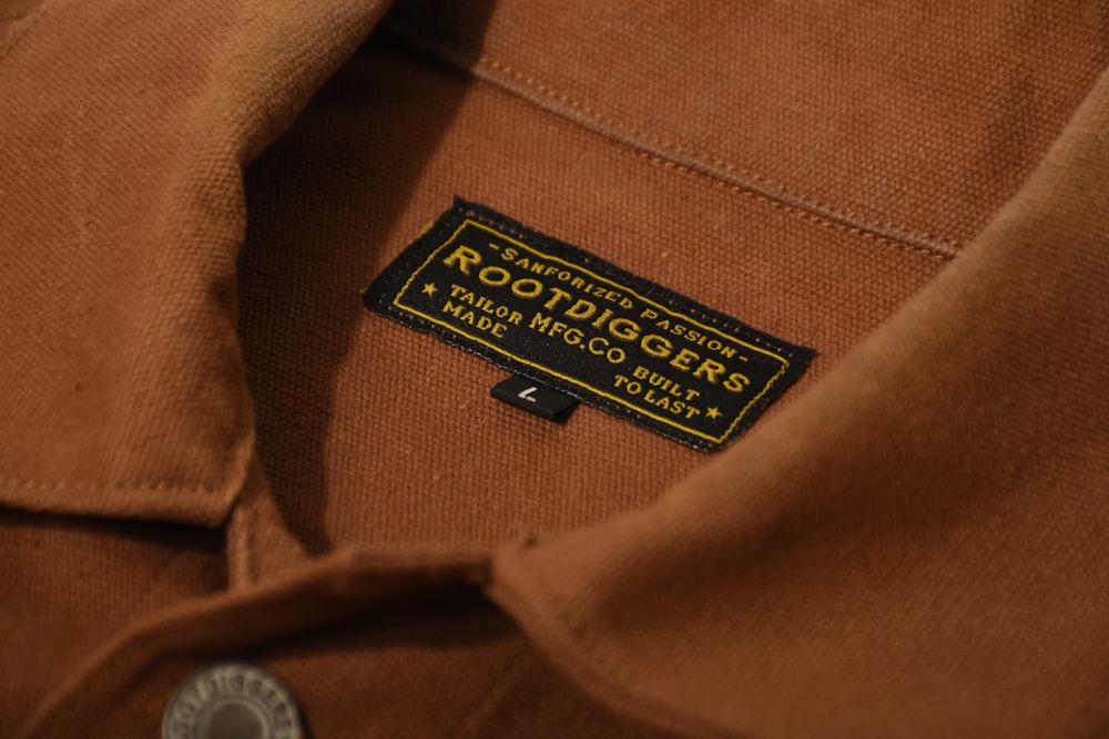 a close up of a brown shirt with a label on it
