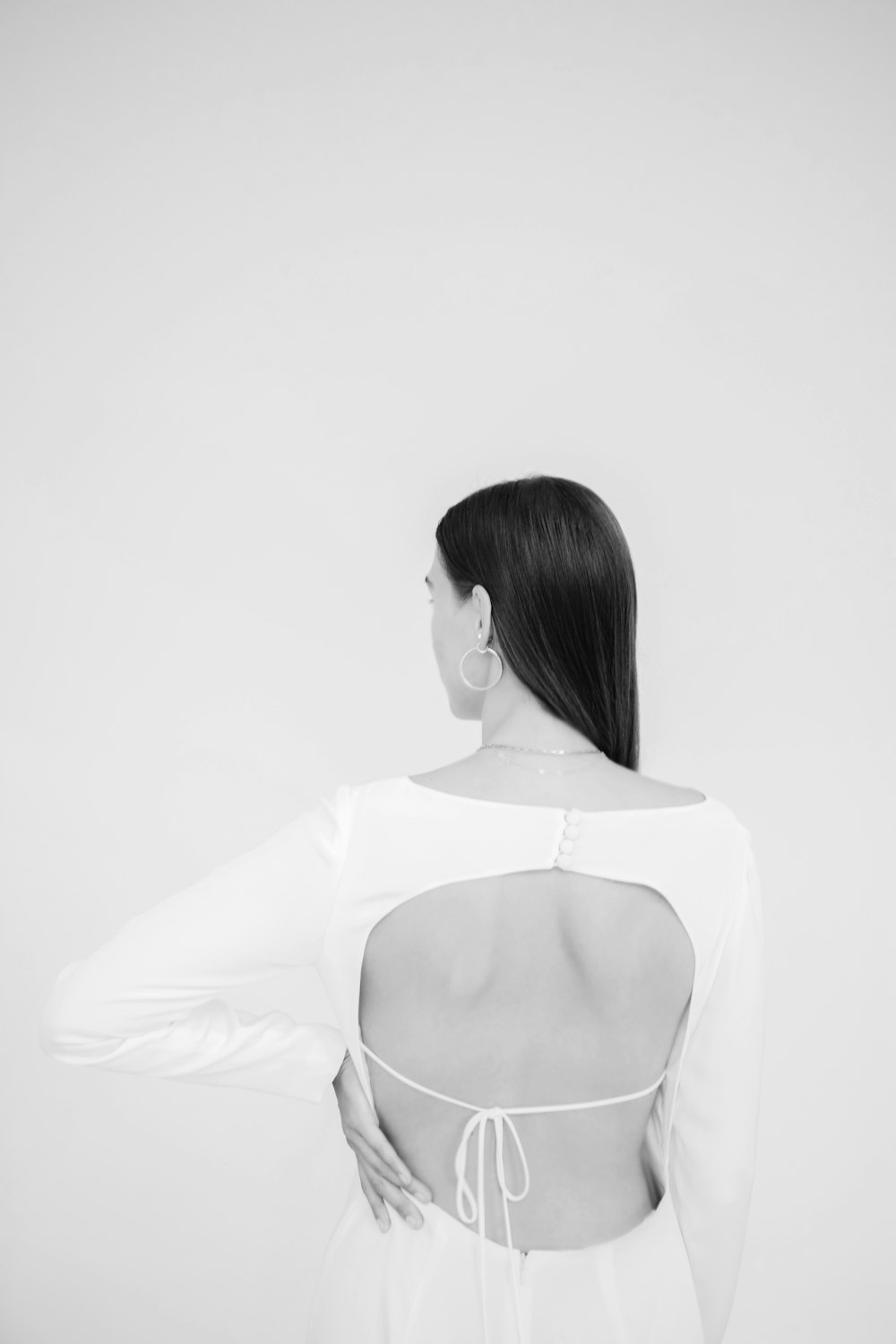 Una donna in abito bianco con le spalle alla telecamera