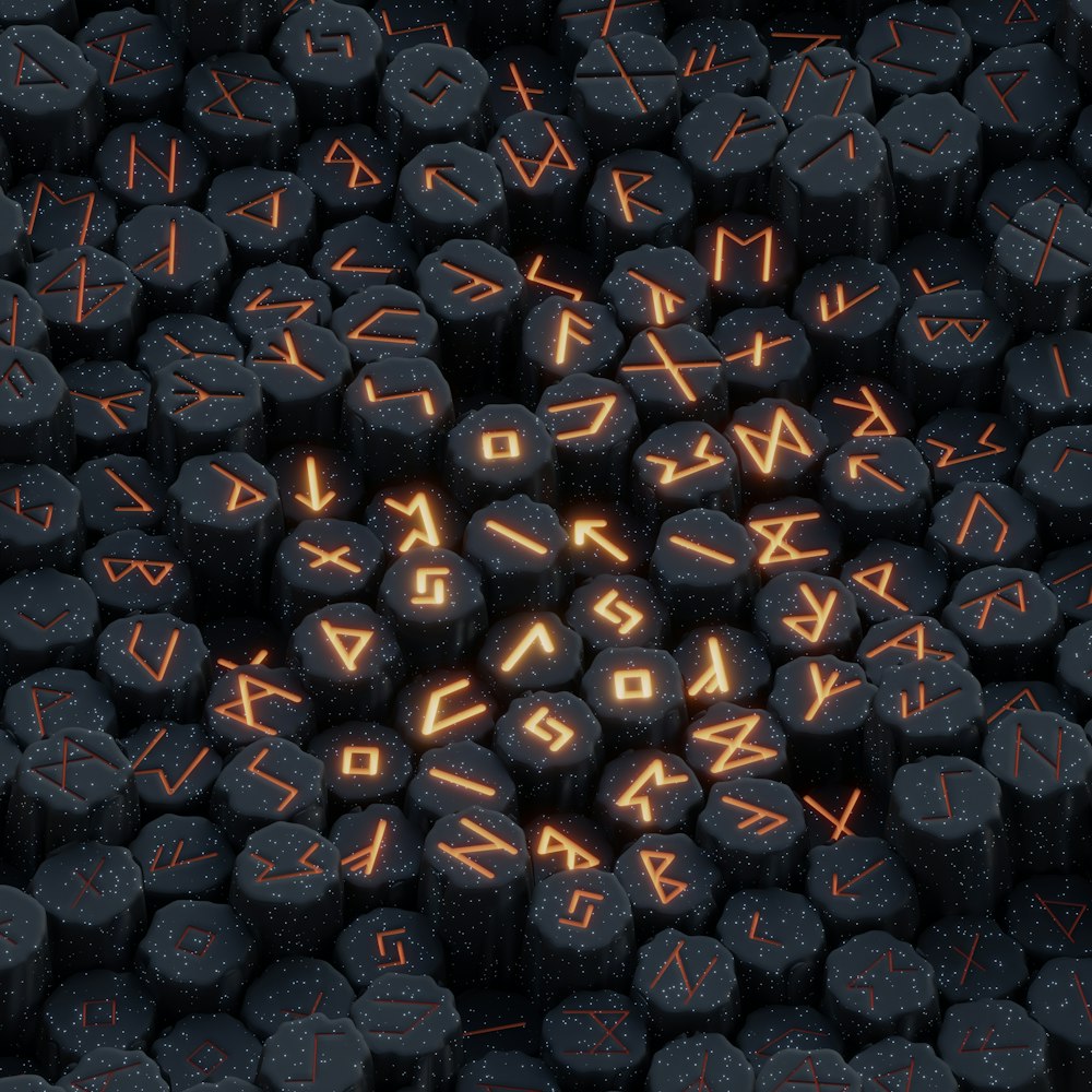 ein Haufen schwarzer Steine mit orangefarbenen Buchstaben darauf
