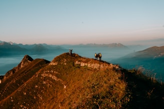 a couple of people standing on top of a mountain