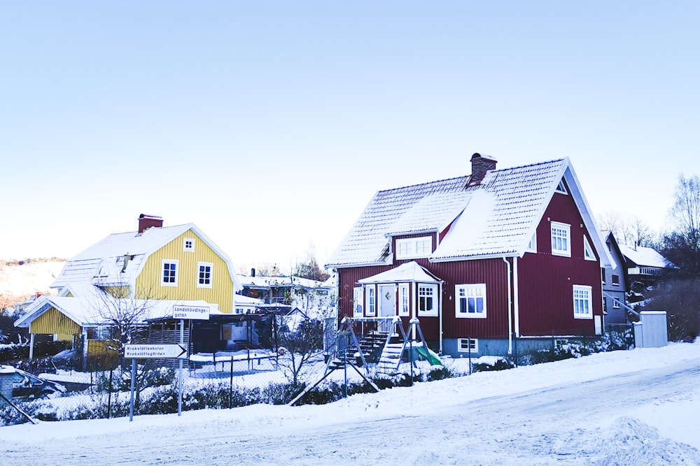 a red and yellow house with snow on the ground