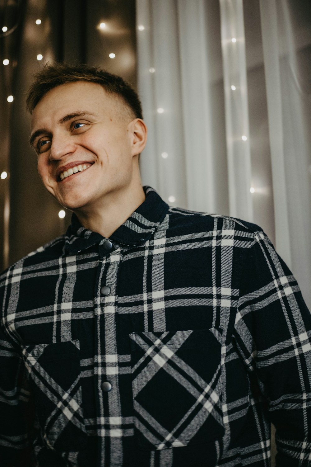 a smiling man in a black and white shirt