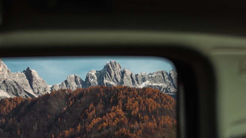 a view of a mountain range through a rear view mirror