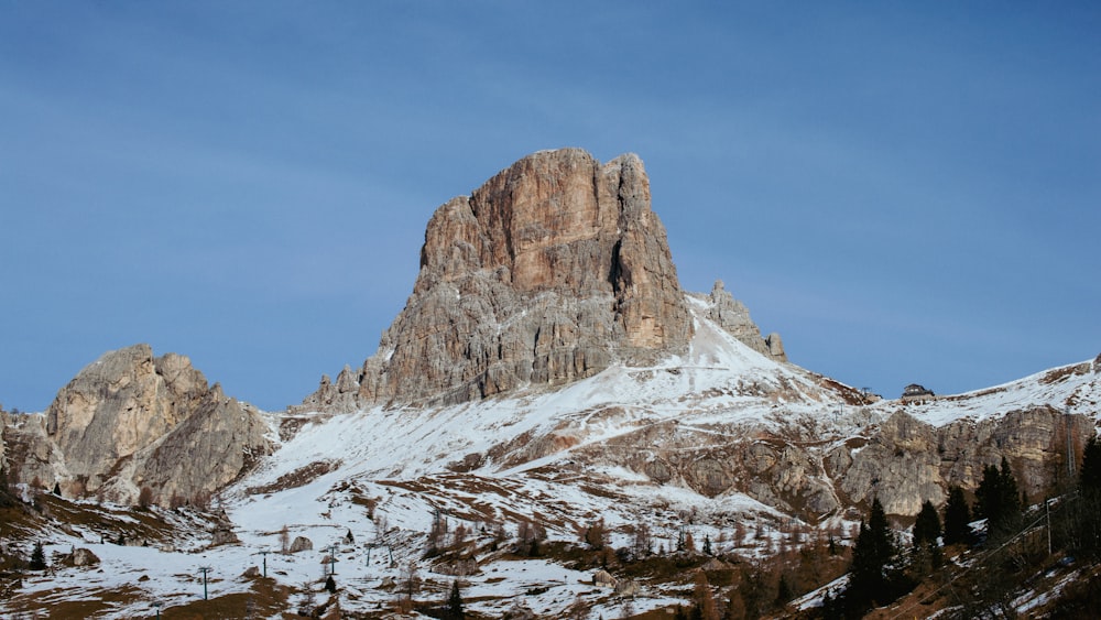 a snow covered mountain with trees in the foreground