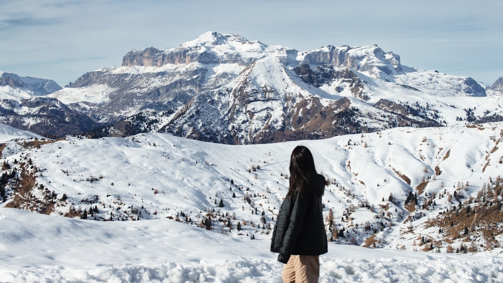 a woman standing on top of a snow covered slope