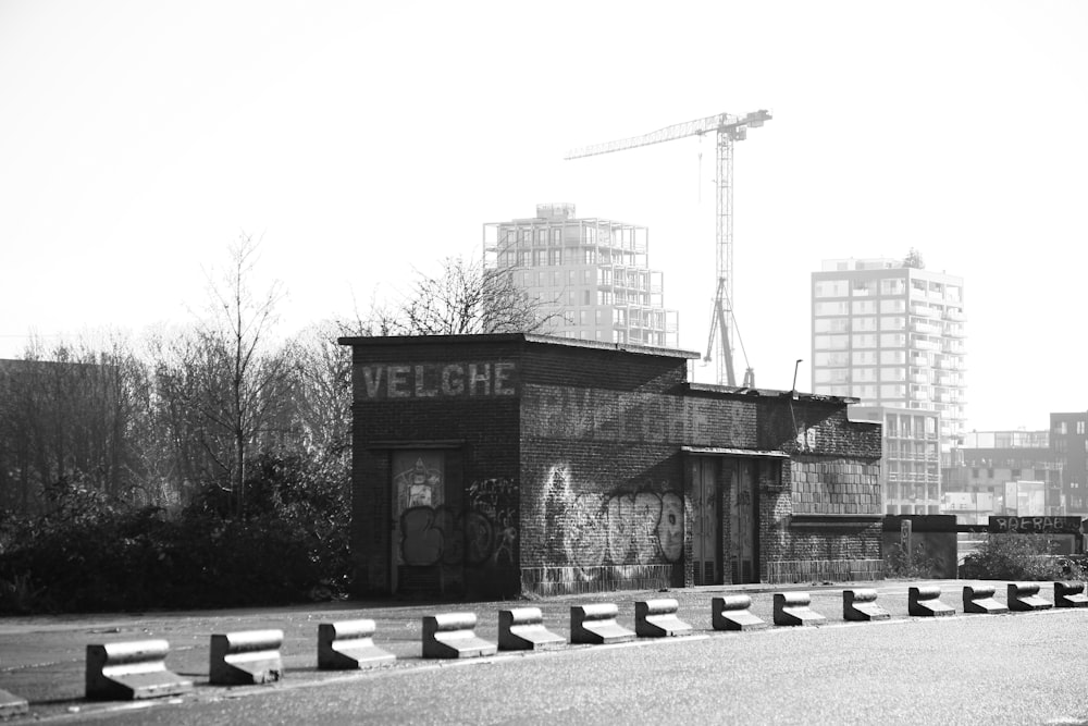 a black and white photo of a building with a crane in the background