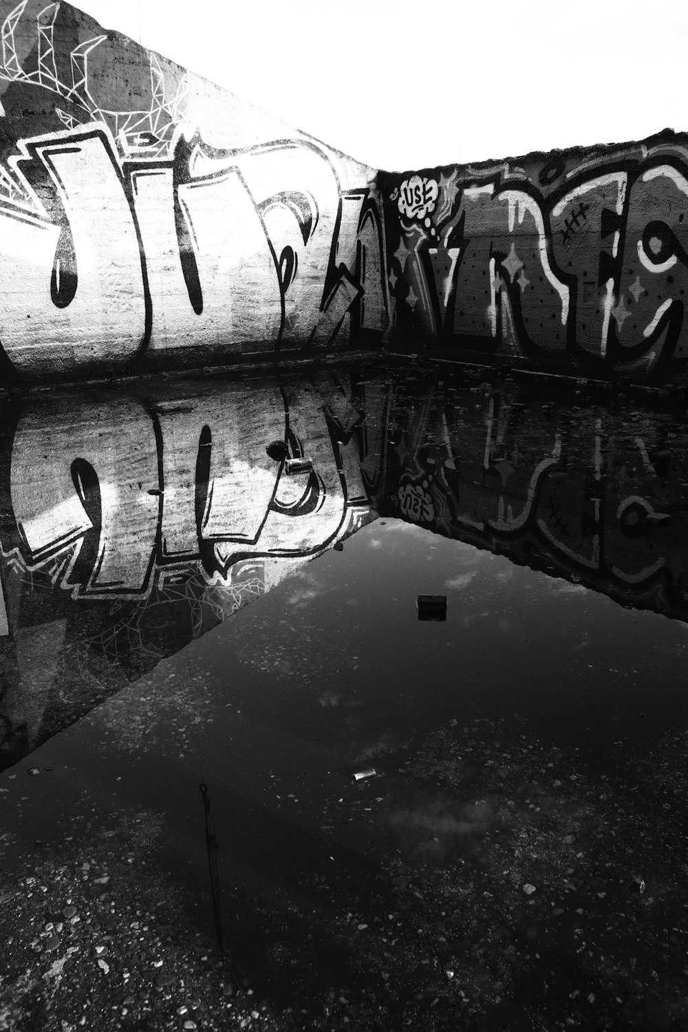 a black and white photo of graffiti on a wall