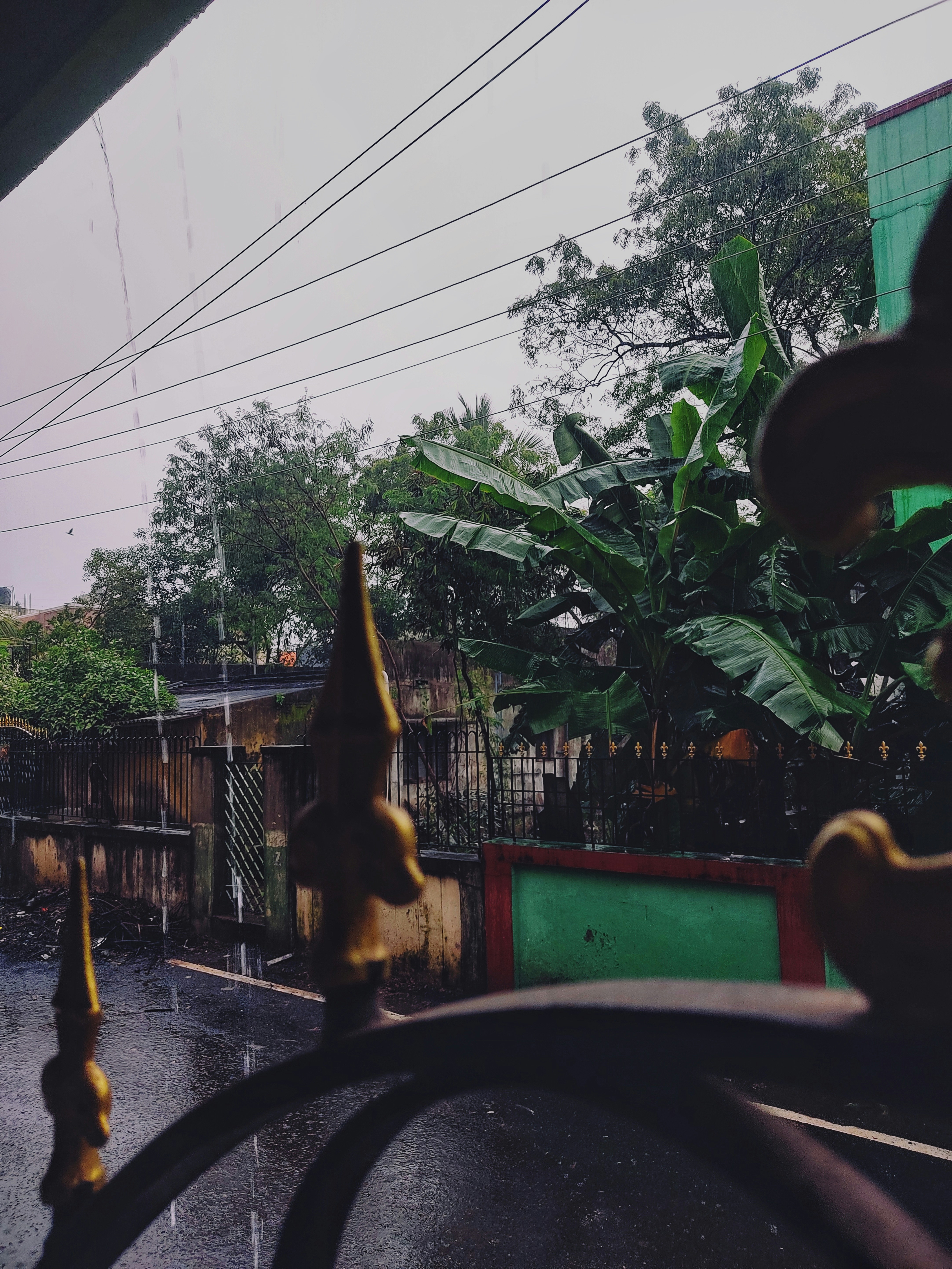 a view of a rain soaked street from inside a bus