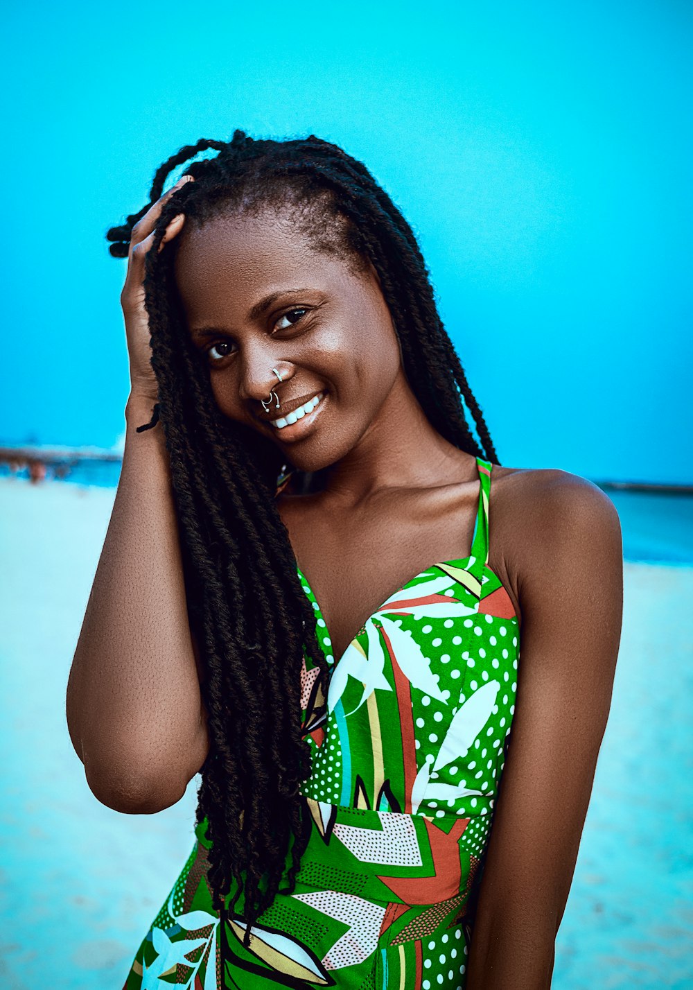 a woman with dreadlocks standing on a beach