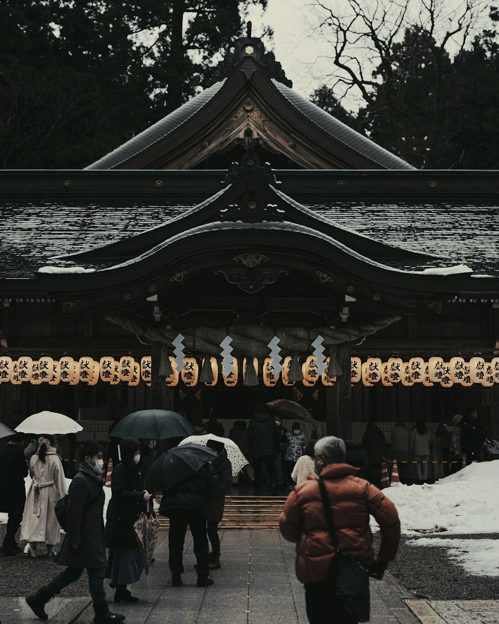 a group of people with umbrellas standing in front of a building