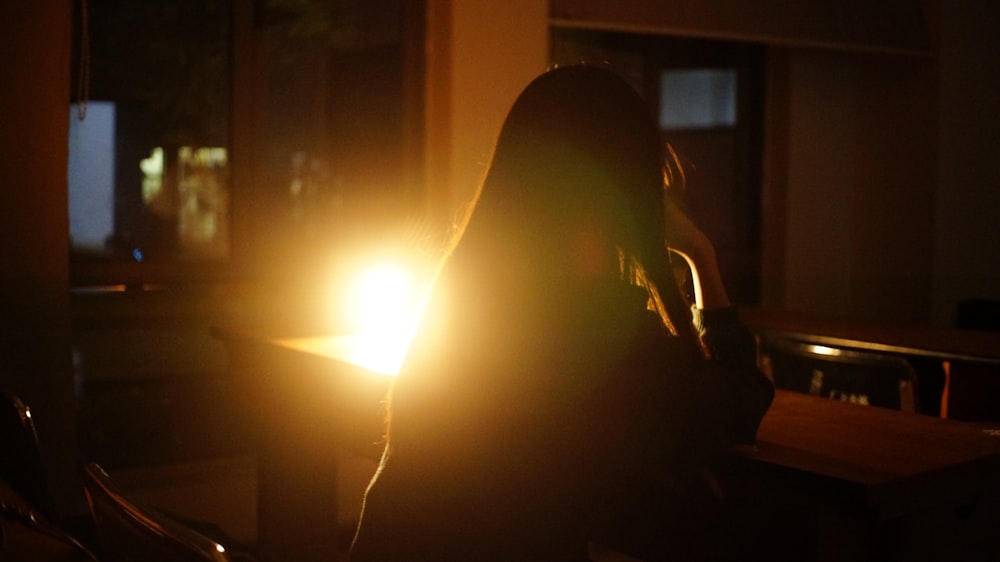 a woman standing in a dark room holding a light