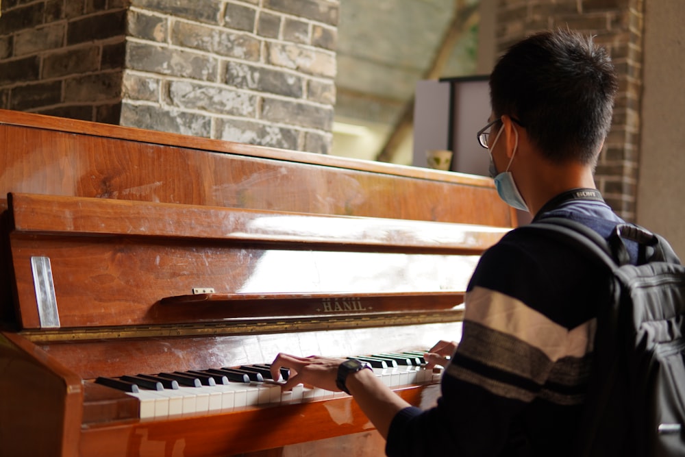 a man wearing a face mask playing a piano